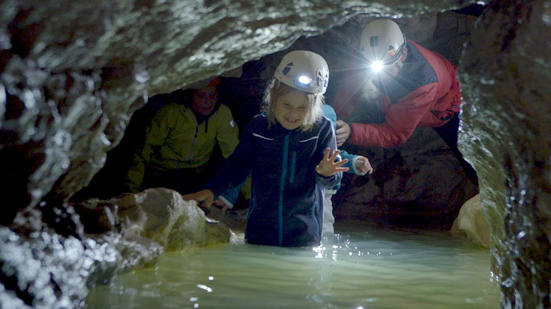 Bei einer Höhlenführung durch die Kreidelucke in Hinterstoder geht es auch durchs Wasser – ein Höhepunkt der unterirdischen Wanderung.